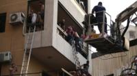 Lebanese citizens flee their house through a balcony at the site of a car bomb