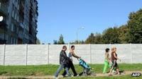 Roma walk past segregation wall in Michalovce, eastern Slovakia, 4 Oct 10