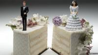 Bride and groom separated on a wedding cake