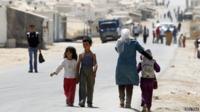 Child refugees walking near to a camp