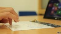 A hand typing on the thin keyboard. It looks barely thicker than a sheet of paper.