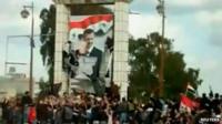 Protesters tear down a portrait of Bashar al-Assad in Deraa (March 2011)