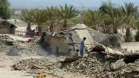 Pakistani survivors remove the debris of their destroyed houses
