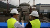 George Osborne (L) talks with Taishan Nuclear Power Joint Venture general manager Guo Liming in front of a nuclear reactor under construction at Taishan, Guangdong province