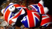 A piggy bank lying on a bed of coins