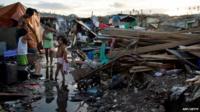 Family stands among rubble in the Philippines