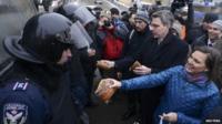 US Assistant Secretary of State Victoria Nuland (R) and US Ambassador Geoffrey Pyatt (2nd R) distribute bread to riot police near Independence square in Kiev on Wednesday