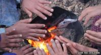 Children's hands around a fire