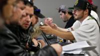 Employee David Marlow, right, helps a customer, who smells a strain of marijuana before buying it, at the crowded sales counter inside Medicine Man marijuana retail store, which opened as a legal recreational retail outlet in Denver 1 January 2014