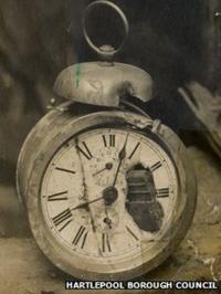 Alarm clock with shell fragment embedded in the workings.