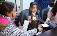 A Syrian girl holds a photo of a Somali refugee who has sent her a letter