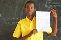 Abshir Hussein holding up his letter while wearing a yellow shirt