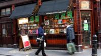 People walking past a record shop