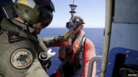 A search team member is lowered into the Indian Ocean to retrieve possible debris