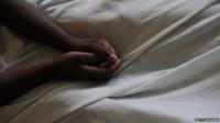 Arms resting on bedsheet