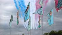 Red Arrows fly past flags