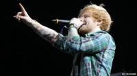 Ed Sheeran performing on stage at T in the Park, pointing to the crowd