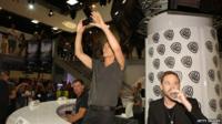 Kevin Bacon at Comic Con holding a mobile phone