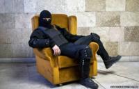 A masked pro-Russian protester sits on a chair as he poses for a picture inside a regional government building in Donetsk, eastern Ukraine