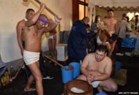 Naked men in loincloths pound steamed rice into a mochi