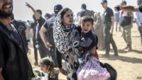 A Syrian Kurdish woman crosses the border between Syria and Turkey at the south-eastern town of Suruc in Sanliurfa province, 23 September 2014