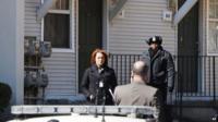 Police wait outside a home in Detroit where two children were found dead