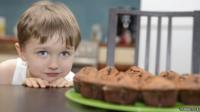 Child eyeing up cake