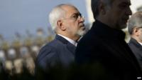Iranian Foreign Minister Javad Zarif (L) walks in a courtyard at the Beau Rivage Palace Hotel in Lausanne on March 28, 2015