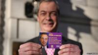 Nigel Farage holding UKIP's pledge card