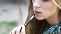 Teenager smoking e-cigarette