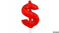 A lolly pop in the shape of a dollar sign
