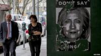 People walk past a Hillary Clinton sign near Clinton"s campaign headquarters in the Brooklyn borough of New York, 14 April 2015