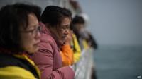 A relative of victims of the Sewol ferry disaster weeps as she and others stand on the deck of a boat during a visit to the site of the sunken ferry off the coast of South Korea's southern island of Jindo on 15 April 2015