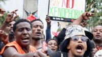Demonstrators take part in an anti-xenophobic march outside the City Hall of Durban on April 8, 2015