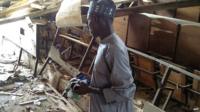 A student looks over at the damage to a lecture hall at the Federal College of Education in the northern Nigerian city of Kano, on September 17, 2014