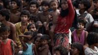 Rohingya migrants stand and sit on a boat drifting in Thai waters off the southern island of Koh Lipe in the Andaman sea on May 14, 2015