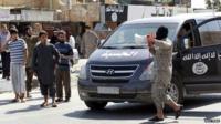 An Islamic State militant announces to residents of Taqba city that the airbase has fallen to IS