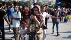 Migrants disembark from ferry from island on Lesbos at port of Piraeus near Athens. 11 July 2015