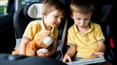 Children in car looking at iPad