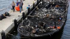 The remains of a victim is carried away after a fire ripped through a boat carrying tourists to islands north of the capital, at Muara Angke port in Jakarta, Indonesia on 1 January 2017