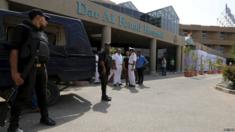 Police stand guard at an Egyptian hospital where ten people mistakenly injured in an anti-terror operation are being treated