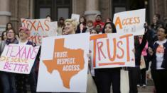 College students and abortion rights activists hold signs during a rally on the steps of the Texas Capitol, in Austin, Texas - 26 February 2015