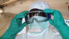 A member of Doctors Without Borders putting on protective gear at the isolation ward of the Donka Hospital in Conakry 28 June 2014