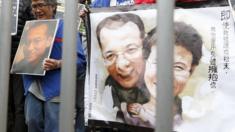 A pro-democracy demonstrator holds a portrait of jailed Chinese Nobel Peace Prize laureate Liu Xiaobo during a protest to call for the freeing of Chinese dissidents outside the Chinese liaison office in Hong Kong, China 25 December 2015.