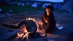 Refugee child at bonfire in makeshift camp at the Greek-Macedonian border near village of Idomeni, on March 3, 2016