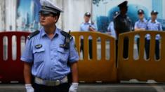 Chinese policemen guard outside a court in Jinan, China - 25 August 2013