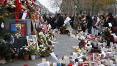 People gather in front of a makeshift memorial at the Place de la Republique in Paris on 13 December 2015, a month after the Paris terror attacks that claimed 130 lives