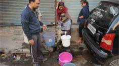 Children collect water from a hand pump in Azadour area north of Delhi on 22 February 2016