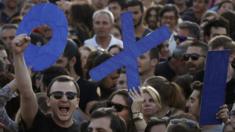 Demonstrators hold up letters spelling the word 