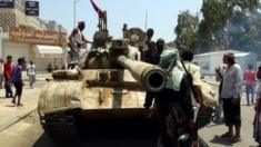 Tribal militiamen loyal to the Yemeni President gather beside a tank during clashes with Houthi fighters in the southern port city of Aden, Yemen, 2 April 2015.